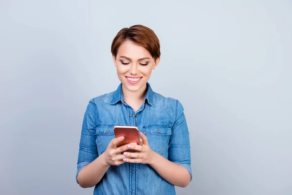 Portret van mooie jonge meisje haar telefoon kijken en smilin — Stockfoto