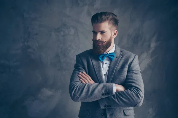 Homem elegante confiante em terno e arco com barba cruzando seu ha — Fotografia de Stock