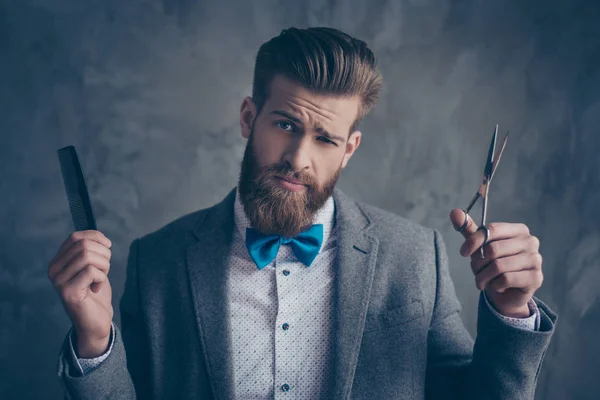 Fiducioso uomo alla moda in giacca e cravatta e fiocco scegliendo tra le forbici — Foto Stock