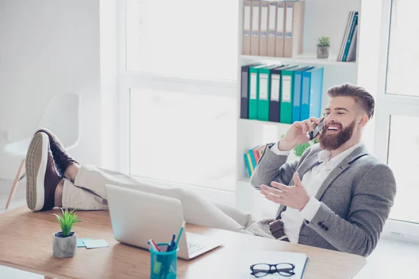 Fröhlicher junger erfolgreicher Mann telefoniert am wor — Stockfoto