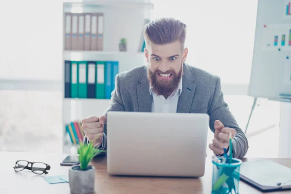 Frustrato giovane uomo d'affari barbuto urlando al suo computer portatile in di — Foto Stock