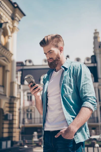 Stylish young red bearded man in casual trendy jeans outfit is t