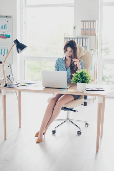 Фотография в полный рост элегантной бизнес-леди, сидящей в своем офисе — стоковое фото