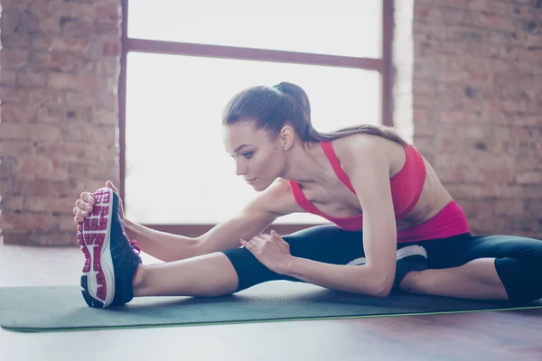 Focused young lady is doing her stretching to be bendy and flexi — Stock Photo, Image