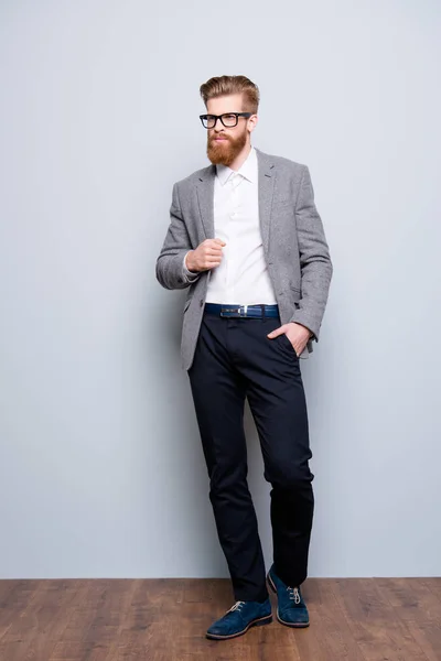 Retrato em tamanho completo de jovem barbudo elegante em pé sobre cinza — Fotografia de Stock