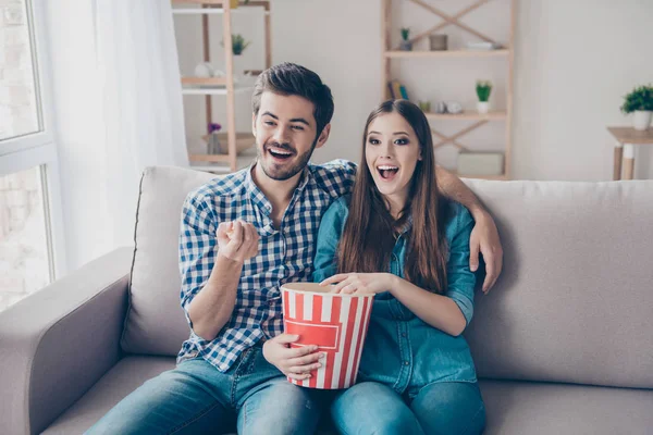 Jovem lindo casal está assistindo filme dentro de casa, comendo — Fotografia de Stock