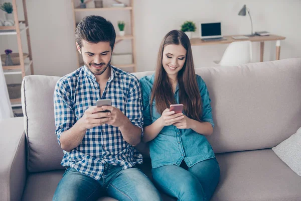 Hermoso hermano relajado y hermana están navegando en su teléfono —  Fotos de Stock