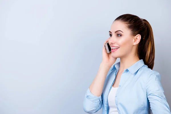 Csinos, fiatal nő mosolygó kék inget beszél a mobiltelefon — Stock Fotó