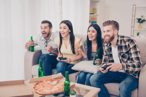 Vier Freunde, Fans von Spielen, sitzen auf dem Sofa in schönen gemütlichen ho — Stockfoto