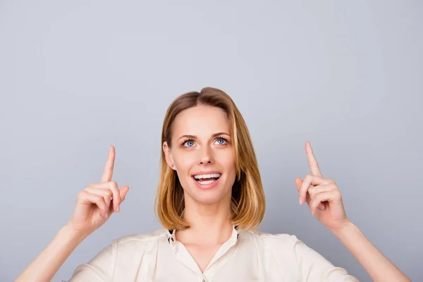 Primo piano della giovane donna bionda stupita con una camicia beige, in piedi — Foto Stock