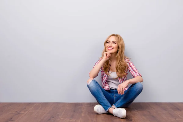 Tankfull ung söt leende kvinna sitter på golvet och thi — Stockfoto