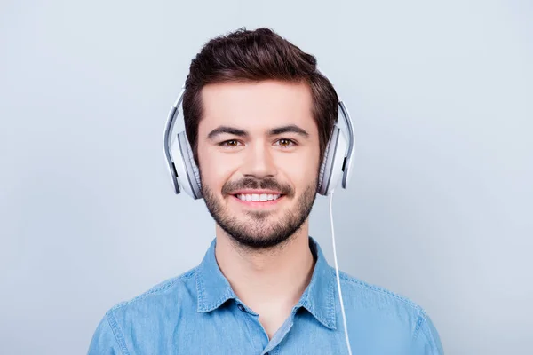 Felice giovane ragazzo carino sta ascoltando la musica in grande testa bianca — Foto Stock