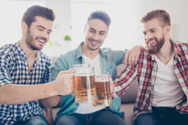 Retrato de cerca de tres hombres felices amigos, tintineando con cristales — Foto de Stock