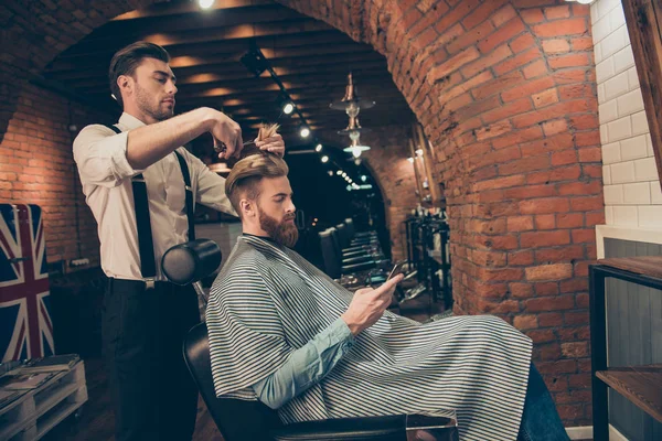 Side view of handsome young red bearded man browsing at his pda, — Stock Photo, Image