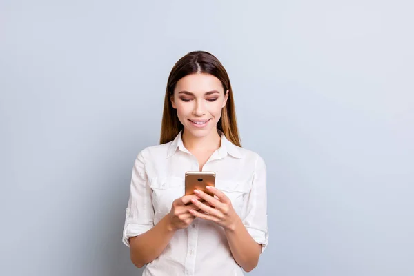 Atractiva joven dama se centra en la lectura de información sobre su teléfono móvil — Foto de Stock