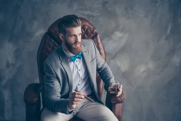Portrait of handsome elegant young red bearded man holding glass