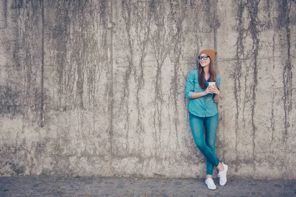 Pleine grandeur de jeune femme gaie, debout près du mur de béton ou — Photo