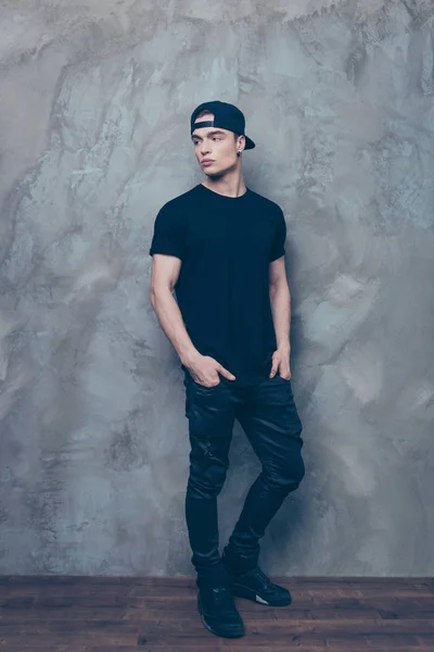 Full size portrait of attractive young man in cap and black cool Stock Picture