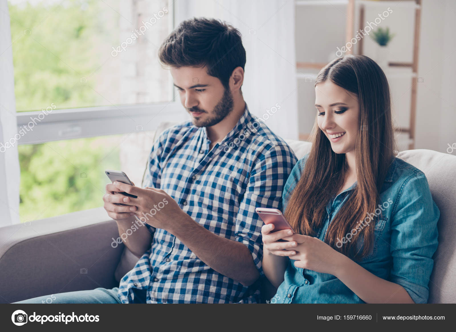 Young cute married couple is browsing information at their pdas Stock