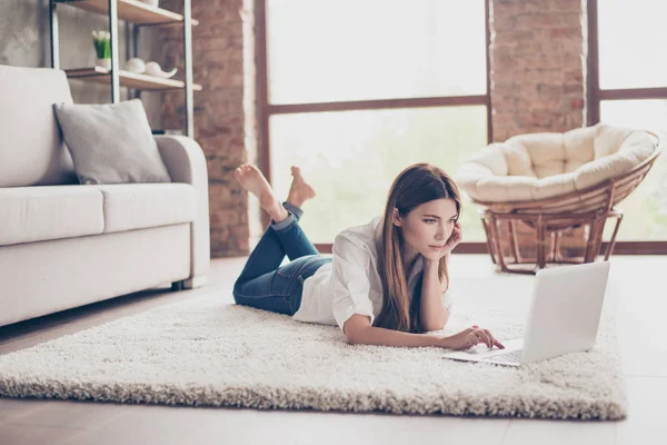 Serious joven dama está estudiando, acostado en la acogedora alfombra en livi — Foto de Stock