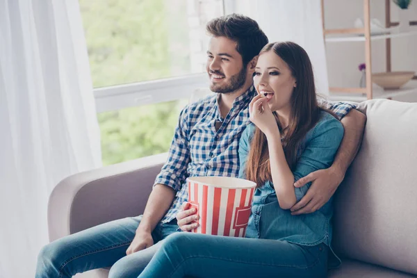 Alegre casal está assistindo comédia dentro de casa, comer popco — Fotografia de Stock