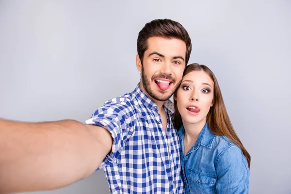 Funky glada unga par att göra selfie foto på guy's kamera. — Stockfoto