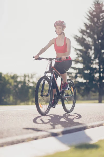 Симпатична струнка дівчина спорту їде на сучасному велосипеді на відкритому повітрі в хорошій — стокове фото