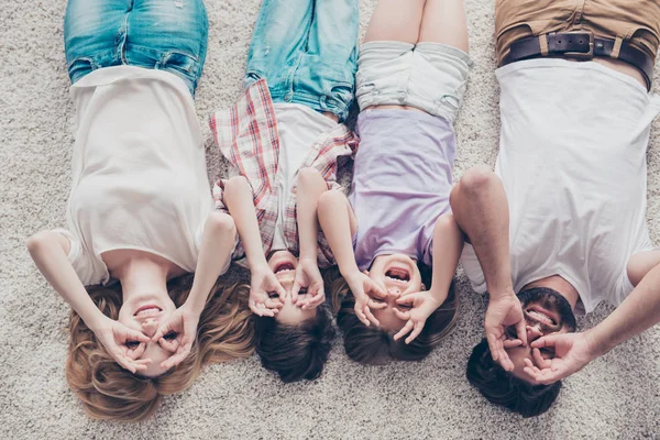 Blick von oben auf glückliche vierköpfige Familie scherzhaft, auf dem Boden liegend — Stockfoto