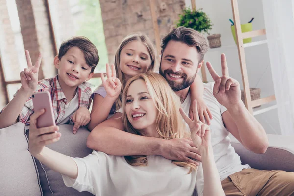 Family portrait of four, showing peace signs. Happy parents and — Stock Photo, Image