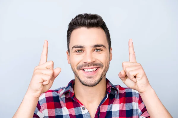 Olha para cima! Jovem homem alegre com sorriso radiante está apontando para cima wi — Fotografia de Stock