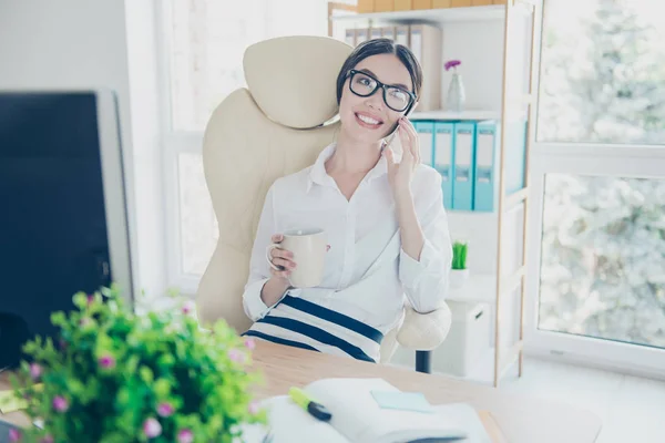 Χαμογελαστός νεαρός πανέμορφο κορίτσι της Ασίας Γραμματέας είναι πίνοντας τσάι στο διάλειμμα στο γραφείο και να μιλήσουμε στο pda σε ωραίο χώρο εργασίας, φορούν επίσημη ένδυση, γυαλιά — Φωτογραφία Αρχείου