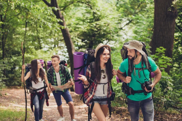 Four tourists got lost in the forest, trying to find the way, looking serious and focused, all having backpacks, mates, all needed for overnight stay — Stock Photo, Image