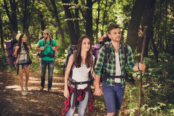 Fyra turister gick vilse i skogen, försöker hitta vägen, ser allvarlig och fokuserad, alla med ryggsäckar, kompisar, alla behövs för övernattning bo — Stockfoto