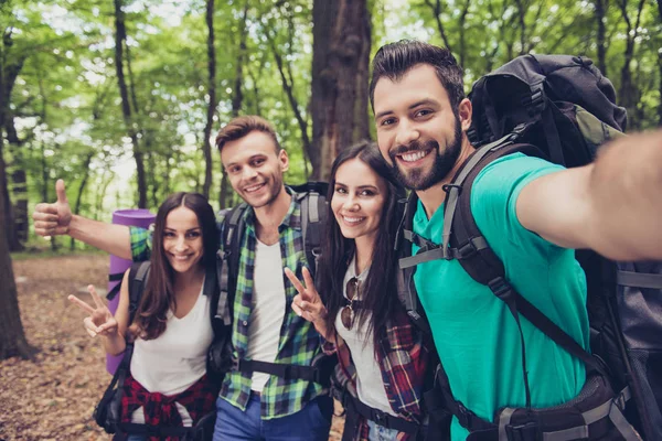 Trekking, camping and wild life concept. Four best friends are hiking in the spring woods, ladies are talking and laughing, all are excited and anxious in  jungle trail — Stock Photo, Image