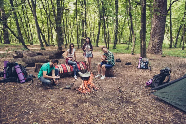 Trekking, camping y concepto de vida salvaje. Cuatro mejores amigos están de excursión en el bosque de primavera, las damas están hablando y riendo, todos están emocionados y ansiosos en el sendero de la selva — Foto de Stock