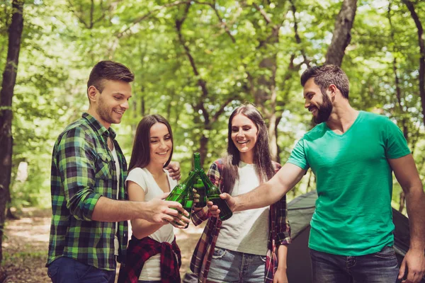 Trekking, camping e conceito de vida selvagem. Quatro melhores amigos estão caminhando nos bosques da primavera, as senhoras estão falando e rindo, todos estão animados e ansiosos na trilha da selva — Fotografia de Stock