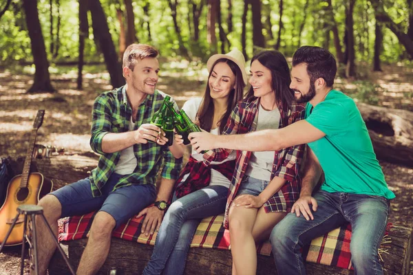 Bliska przycięte portret czterech przyjaciół wesoły w drewno ładne lato. Są one pieszych wycieczek, spacerów i wybierając miejsce na camping, obejmując, pozowanie do zdjęć — Zdjęcie stockowe