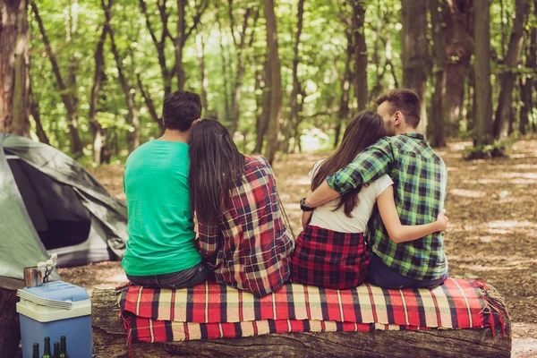 Primer plano retrato recortado de cuatro amigos alegres en el verano agradable madera. Son excursionistas, caminando y recogiendo lugar para acampar, abrazando, posando para la foto — Foto de Stock