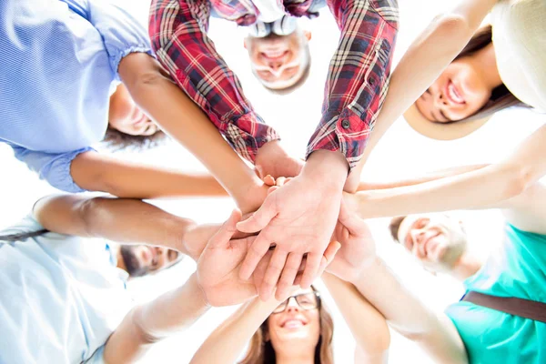 Alle zusammen! Tiefblick auf glückliche Studenten, die ihre Hände in den Schoß legen — Stockfoto