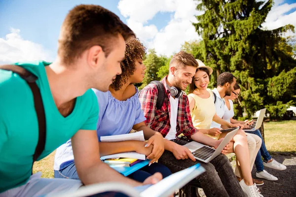 Gros plan recadré od six camarades de classe joyeux, assis sur un b — Photo