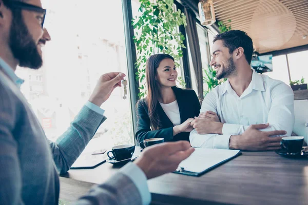 Et lykkelig par omfavner hverandre. De får en nøkkel fra fremtiden. – stockfoto