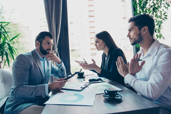 Drie zakelijke partners in slimme slijtage debatteren de financiën — Stockfoto