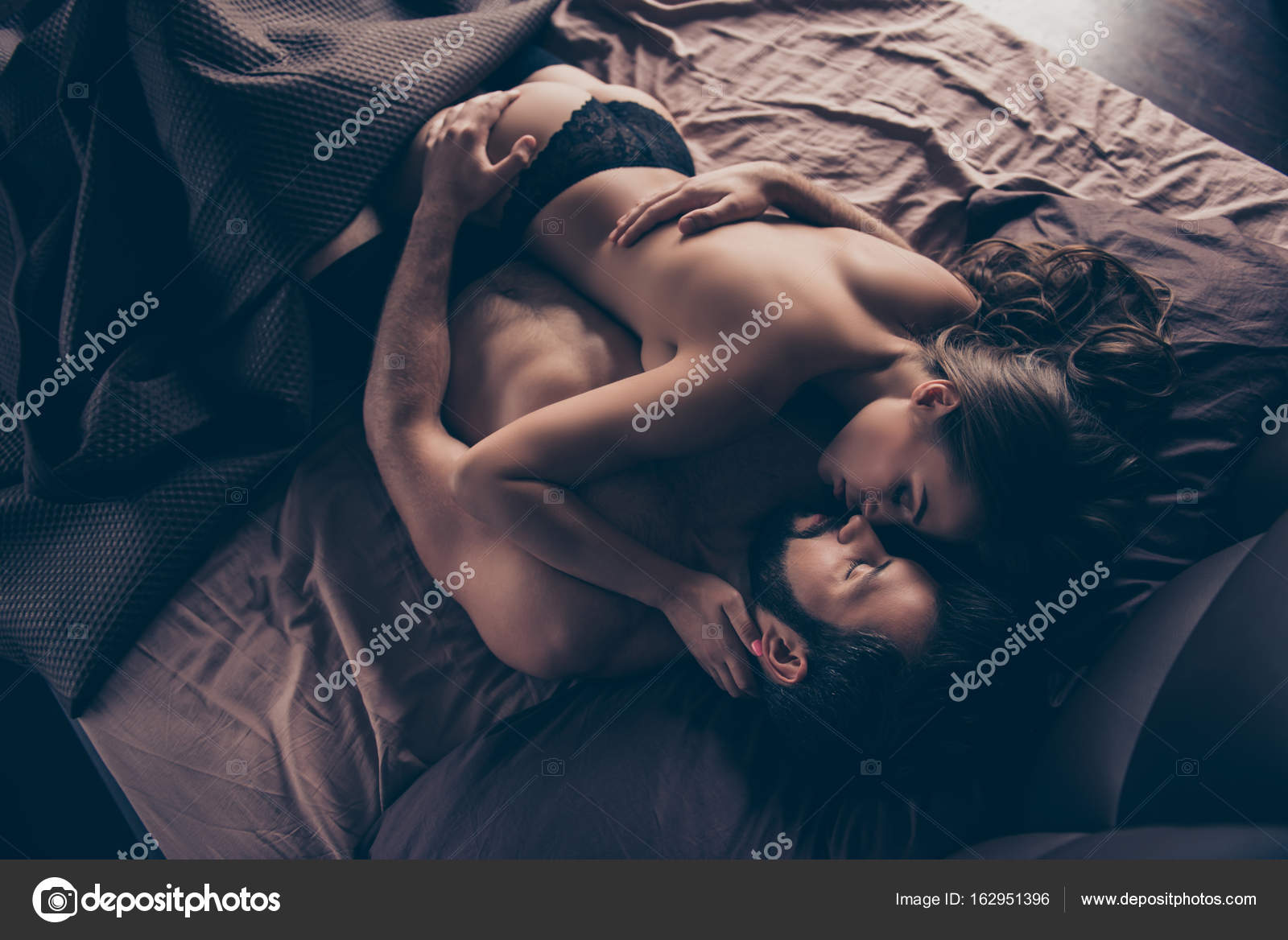 Beautiful half naked married young couple is embracing in the be Stock Photo by ©deagreez1 162951396