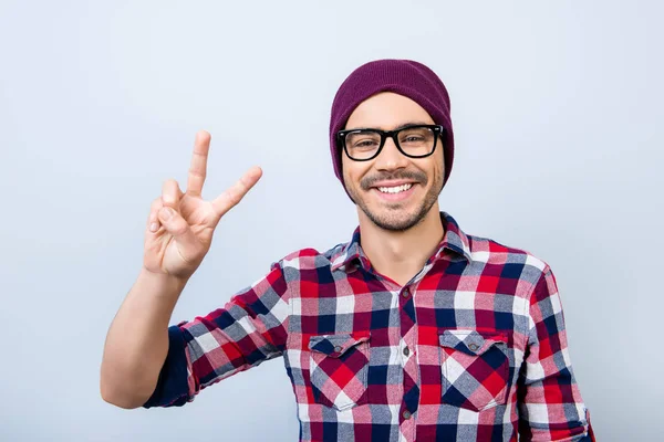 ¡Paz! Sonriendo joven nerd elegante estudiante hipster está haciendo un gesto —  Fotos de Stock