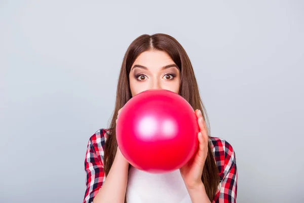 Mladí ohromil hnědovlasá holka fouká červený balón pro oslavu — Stock fotografie