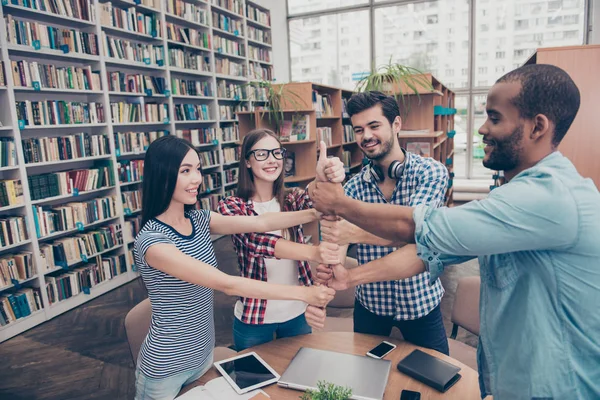 Conceito de trabalho em equipa. Quatro felizes jovens estudantes internacionais putti — Fotografia de Stock