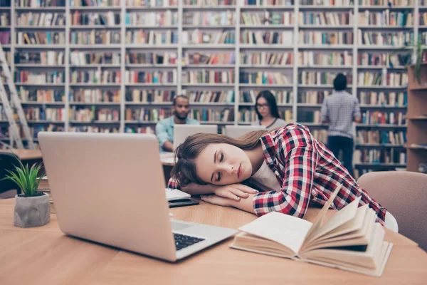 Jovem estudante está cansado e está dormindo na área de trabalho, ele — Fotografia de Stock