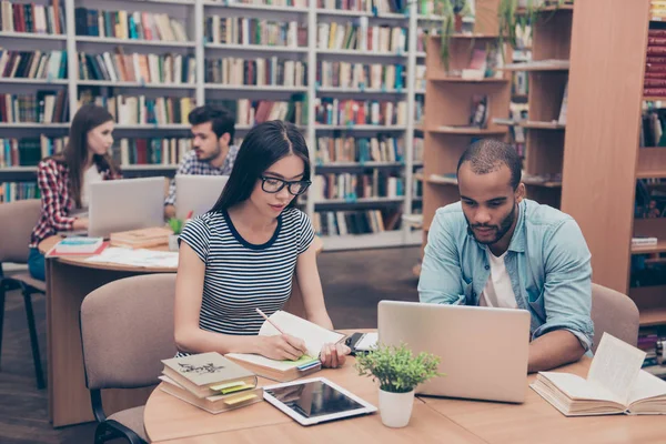 Grupo internacional de cuatro jóvenes estudiantes inteligentes enfocados bookwo —  Fotos de Stock