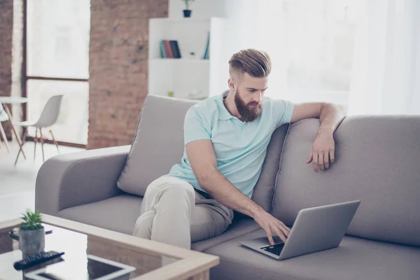 Concentrado joven elegante barbudo rojo freelancer sentado en sof — Foto de Stock