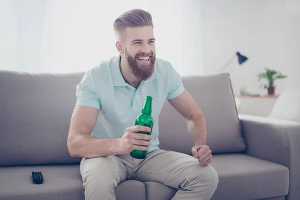 Joven hombre barbudo sonriente feliz con ropa casual sentado en el suelo — Foto de Stock